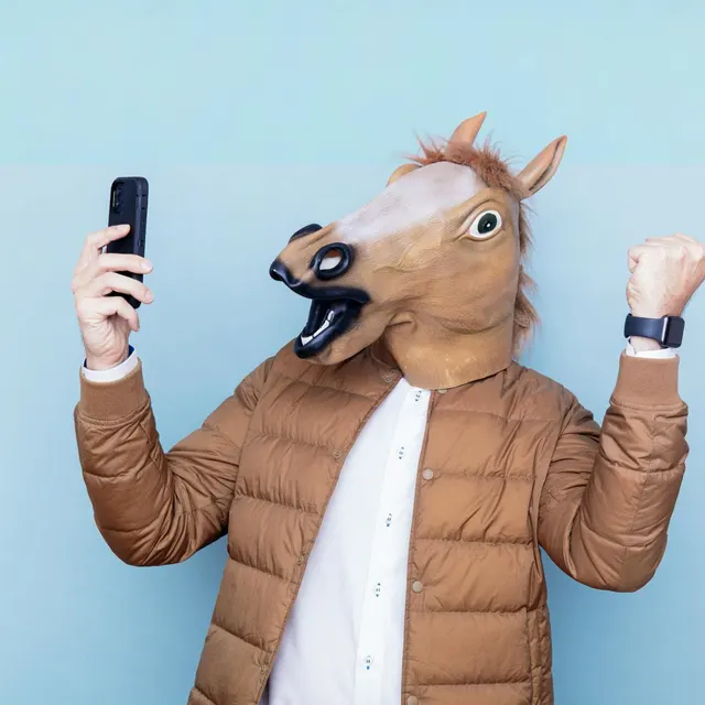A person in a horse mask celebrating with a phone